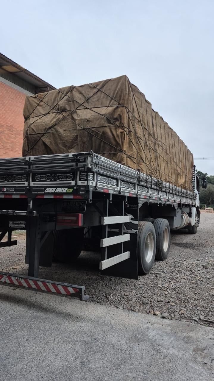 Caminhão da frota JHOW Transportes com carga lonada, pronto para viagem